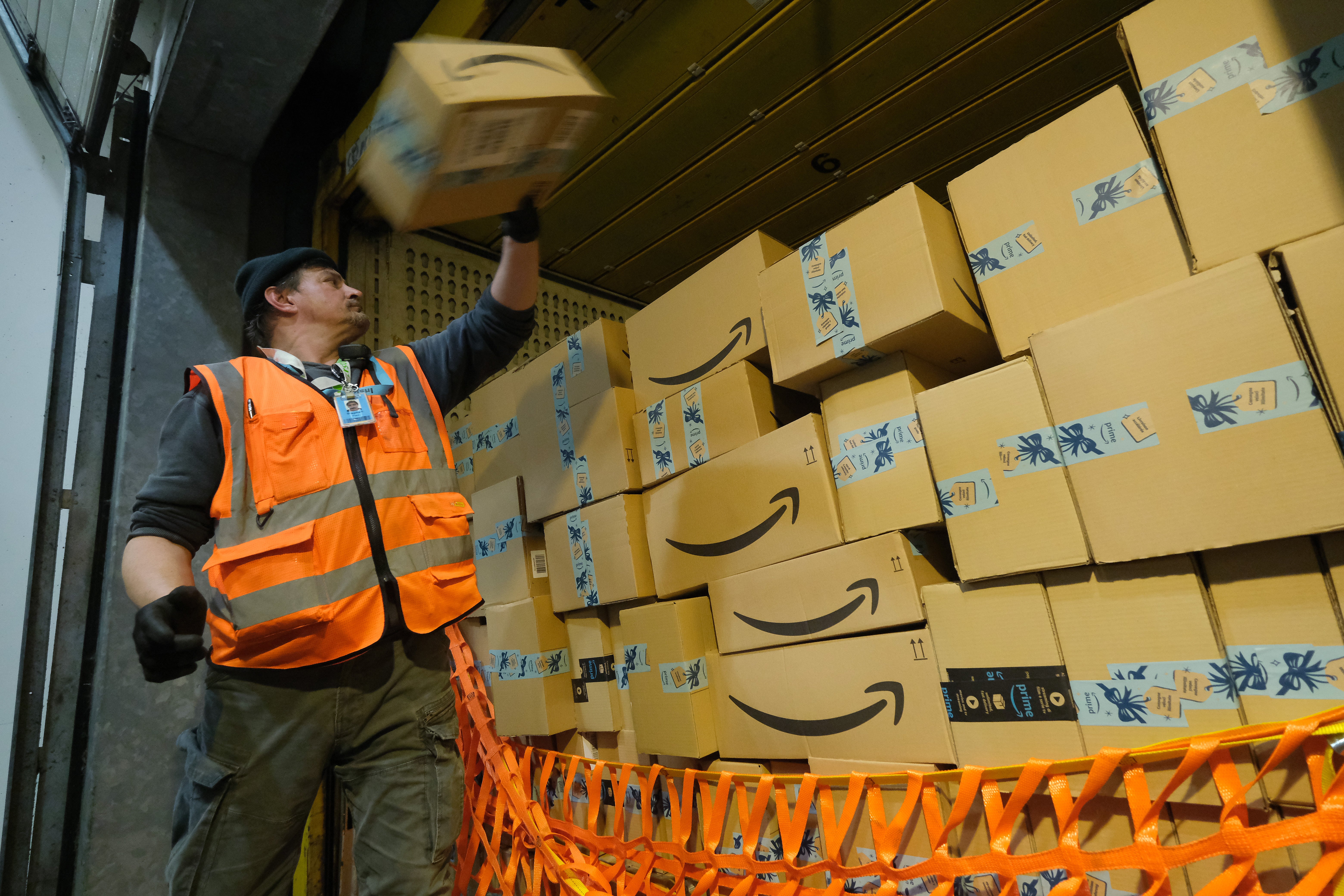 A worker loads a truck with packages at an Amazon packaging center on November 28, 2019 in Brieselang, Germany. (Photo by Sean Gallup/Getty Images)