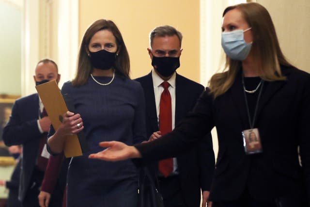 Amy Coney Barrett (centre) and White House counsel Pat Cipollone (second right) enter Mitch McConnell's office at the US Capitol after a day of meetings with Republican senators.
