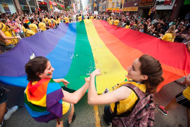 A giant pride flag is carried down Younge Street in Toronto, Ontario during the city's Pride Parade, 25 June 2017