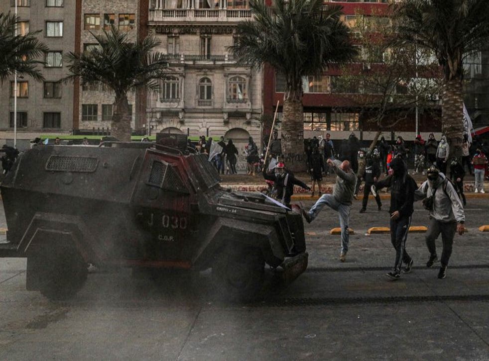 Un manifestante enfrenta un vehículo blindado de la policía durante una protesta contra la brutalidad policial, en Santiago, Chile, el sábado 3 de octubre de 2020. (Foto/Esteban Félix)