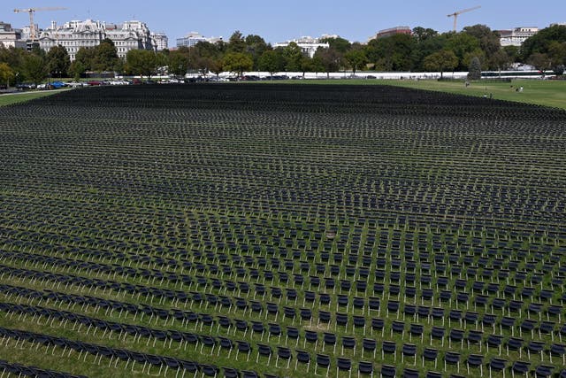 With the White House in the background, 20,000 chairs, each representing 10 deaths from the coronavirus pandemic in the US are lined up on the Ellipse for a remembrance event Sunday