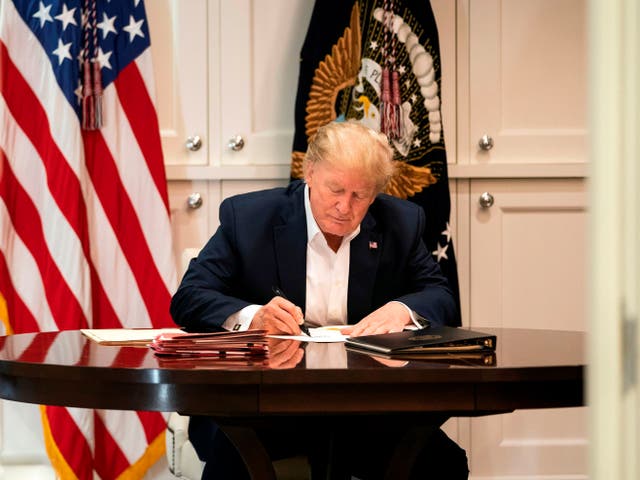 This White House handout photo released 4 October 2020 shows US president Donald Trump working in the Presidential Suite at Walter Reed National Military Medical Centre in Bethesda, Maryland on 3 October 2020, after testing positive for Covid-19