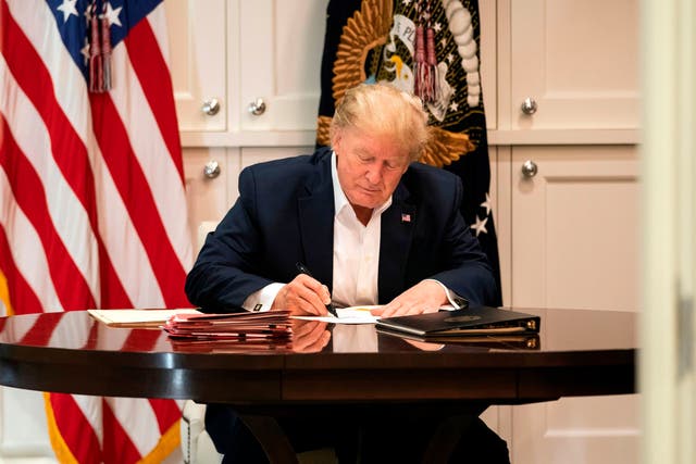 This White House handout photo released 4 October 2020 shows US president Donald Trump working in the Presidential Suite at Walter Reed National Military Medical Centre in Bethesda, Maryland on 3 October 2020, after testing positive for Covid-19
