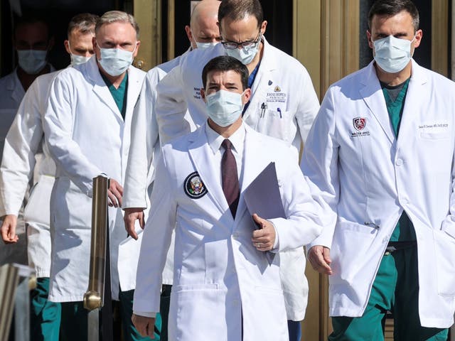 White House physician Dr. Sean Conley is flanked by doctors as he arrives to speak to reporters about U.S. President Donald Trump's health after the president underwent a fourth day of treatment for the coronavirus disease (COVID-19) at Walter Reed National Military Medical Center in Bethesda, Maryland.