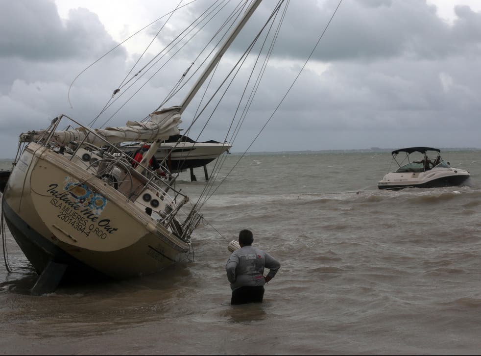 A man looks at a boat stranded at a beach during tropical storm Gamma, in Villahermosa, Mexico, 3 October, 2020