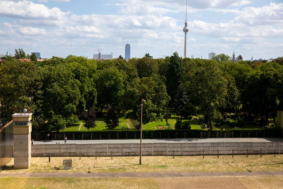 A view of the Berlin Wall Memorial site along Bernauer Street with a watch tower and buffer zone