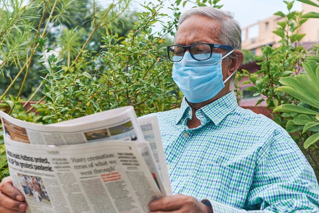 A man reads a newspaper during the coronavirus pandemic.