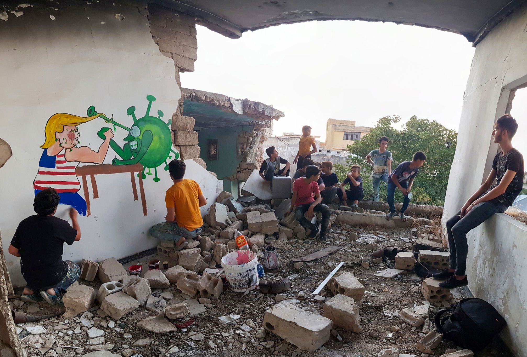 <p>Syrian artists paints a mural in Idlib of Trump&nbsp;</p>