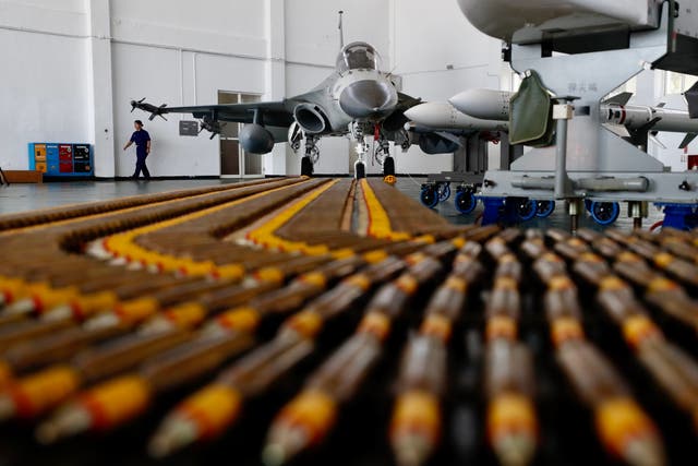 Air force personnel walks past Taiwan's Air Force Indigenous Defense Fighter (IDF) jets inside a hangar