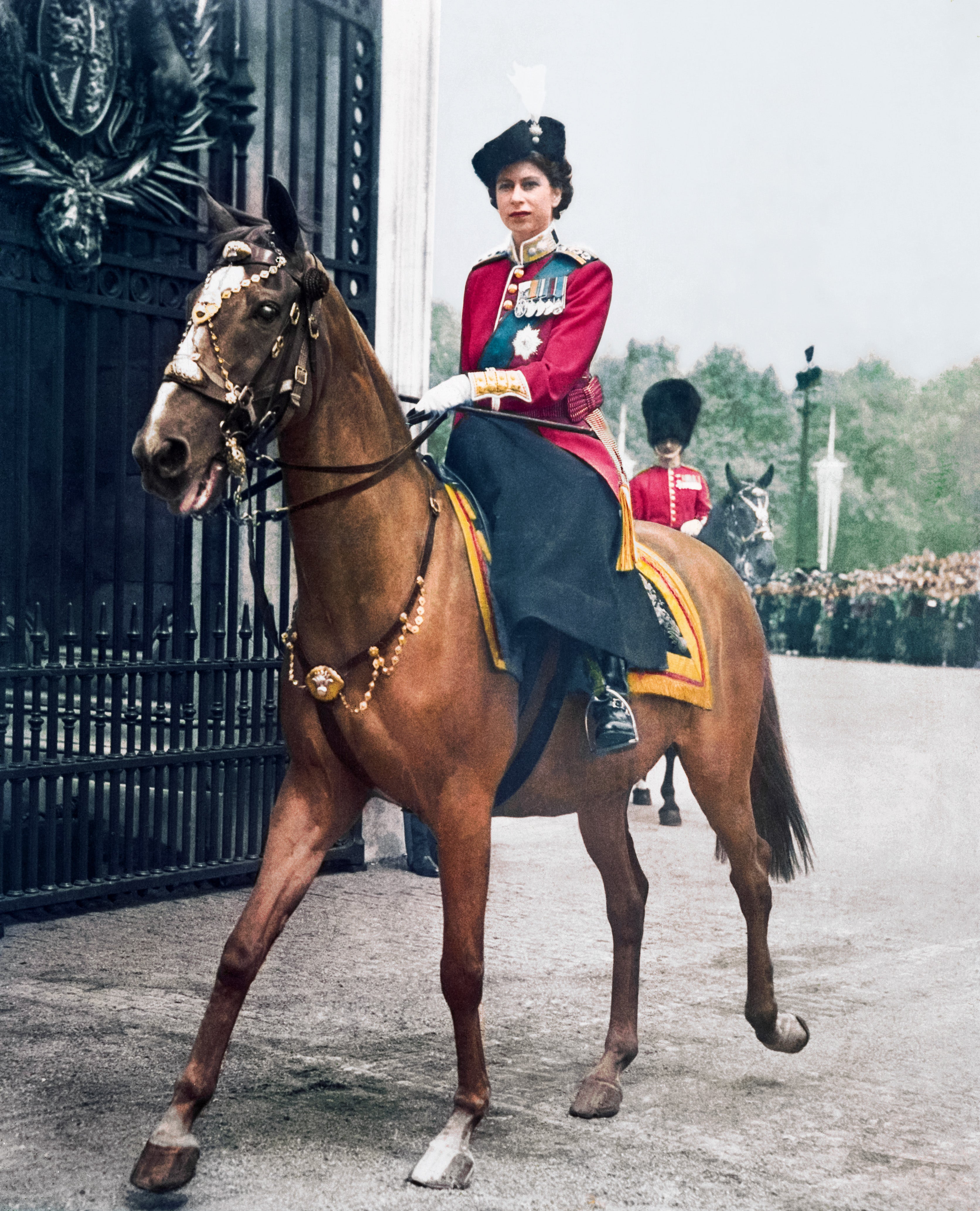 Deputising for her father, Princess Elizabeth took the salute for the ﬁrst time at Trooping the Colour on Horse Guards Parade. She wears the scarlet tunic of the Grenadier Guards, of which she was colonel. 1951.