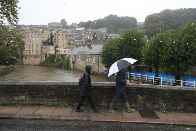 People walk in the rain in Bradford-on-Avon in Wiltshire on 4 October, 2020. 