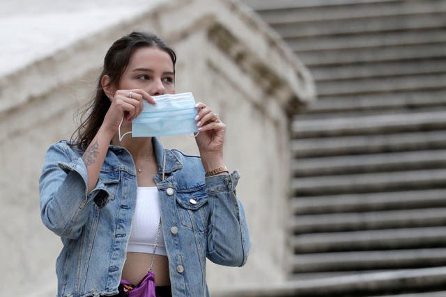 A woman puts on a face mask in Rome on 6 October, 2020. 