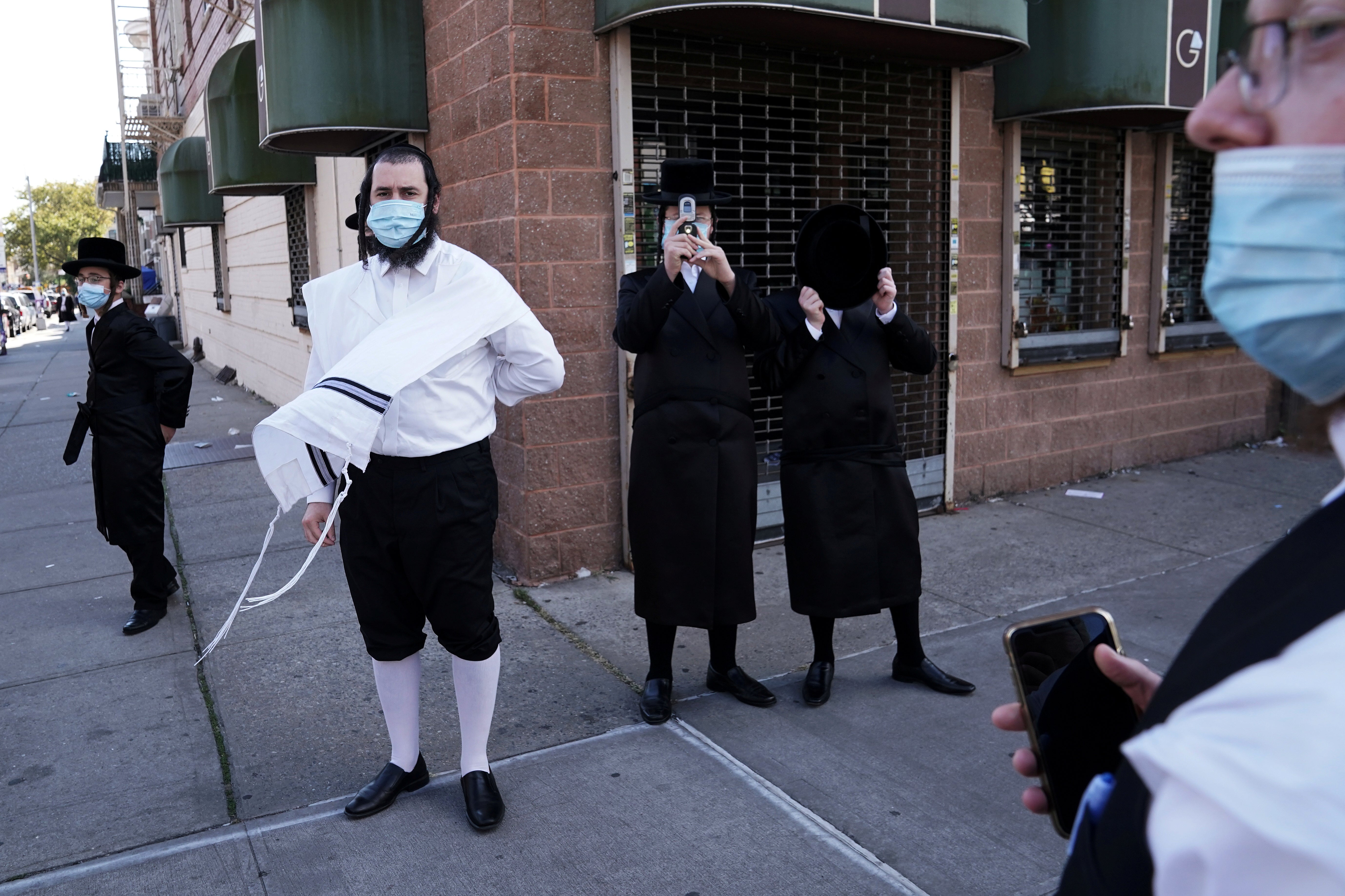 Ultra-Orthodox Jewish men surround and taunt a photographer during the coronavirus disease (COVID-19) pandemic in the Borough Park section of the Brooklyn borough of New York City.