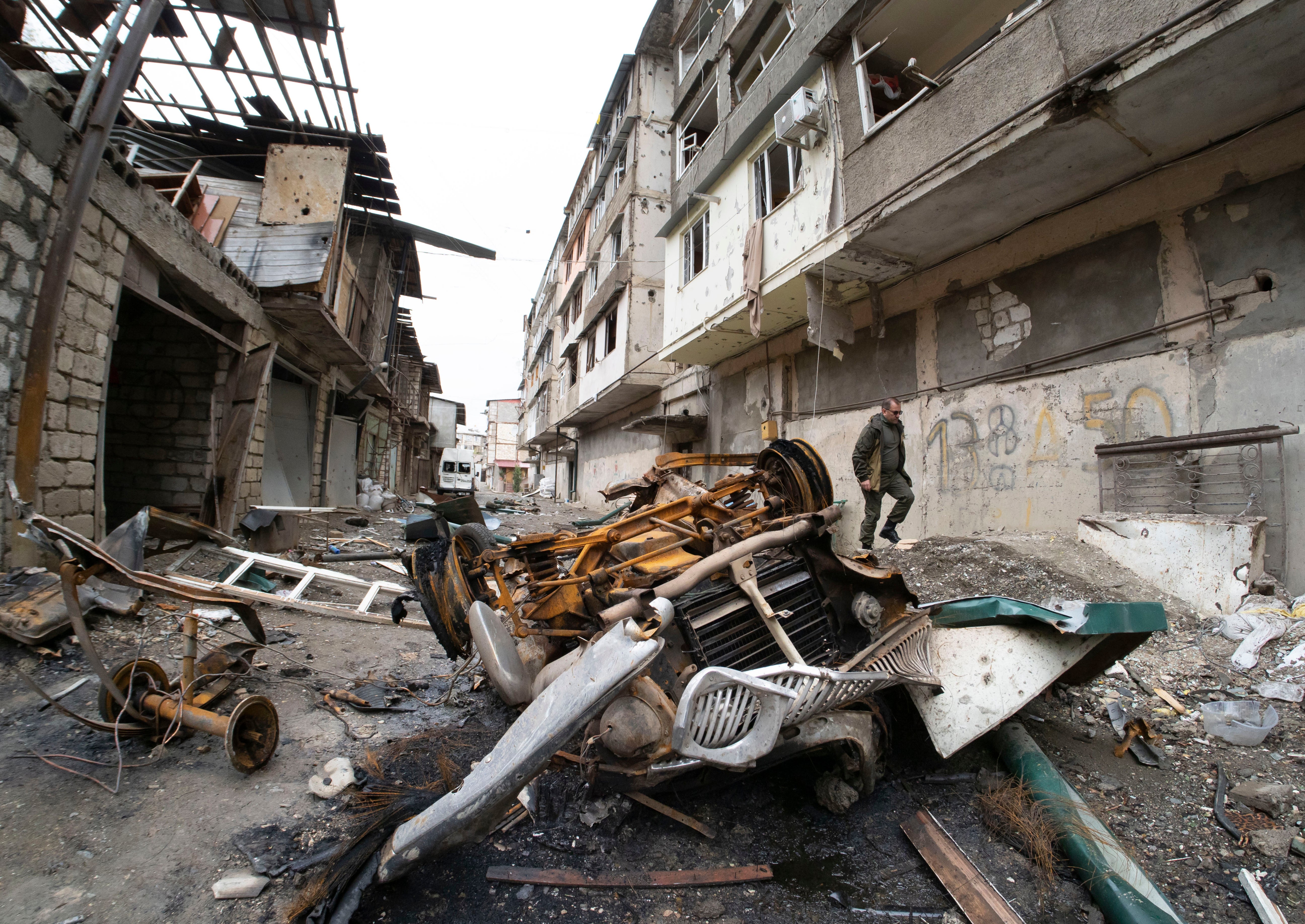 A man walks in the yard of an apartment building damaged by shelling by Azerbaijan’s artillery during a military conflict in Stepanakert, self-proclaimed Republic of Nagorno-Karabakh (AP Photo/Dmitri Lovetsky)