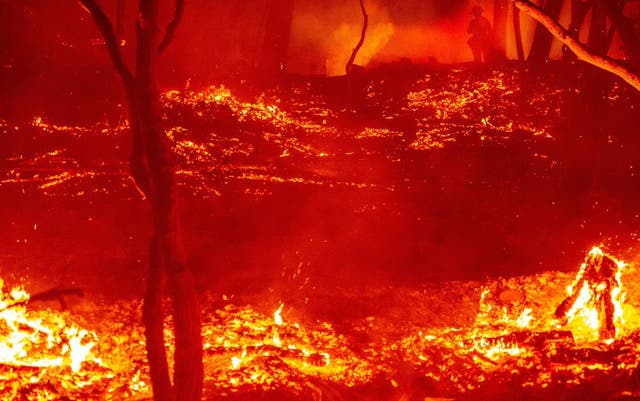 Firefighters work at the scene of a burning property as fires continues in Calistoga, California