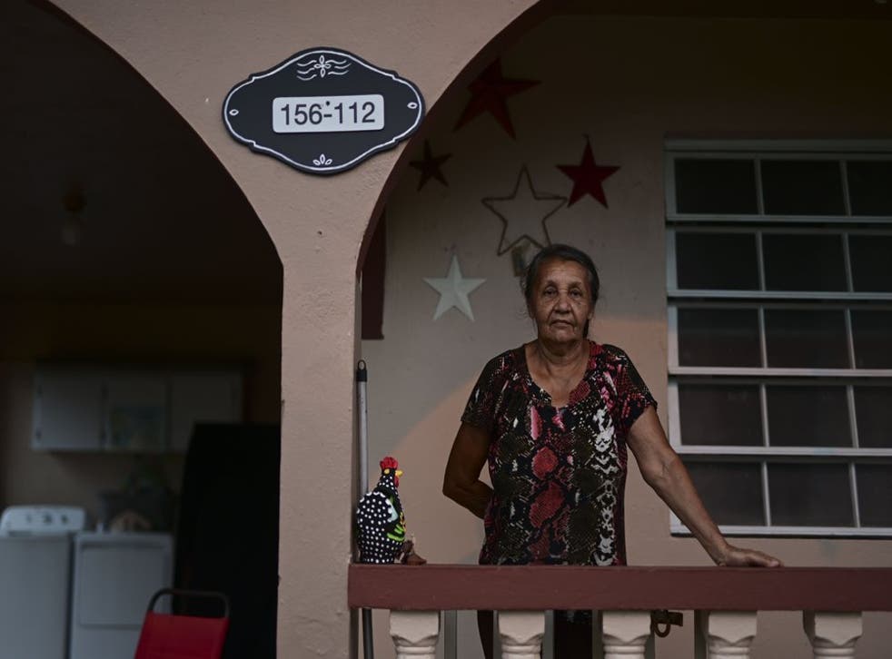Cándida Díaz posa para una foto en su casa de Caguas, Puerto Rico, a la que hace poco se le asignó por primera vez un número.