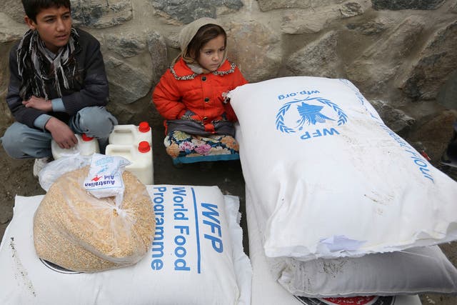 Children wait for transportation after receiving food donated by the World Food Program, in Kabul, Afghanistan