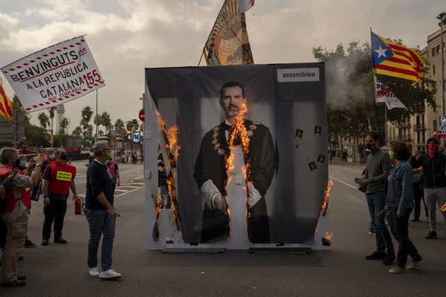Unas personas queman una imagen del rey Felipe VI de España durante una protesta en Barcelona, el viernes 9 de octubre de 2020. (Foto/Emilio Morenatti)