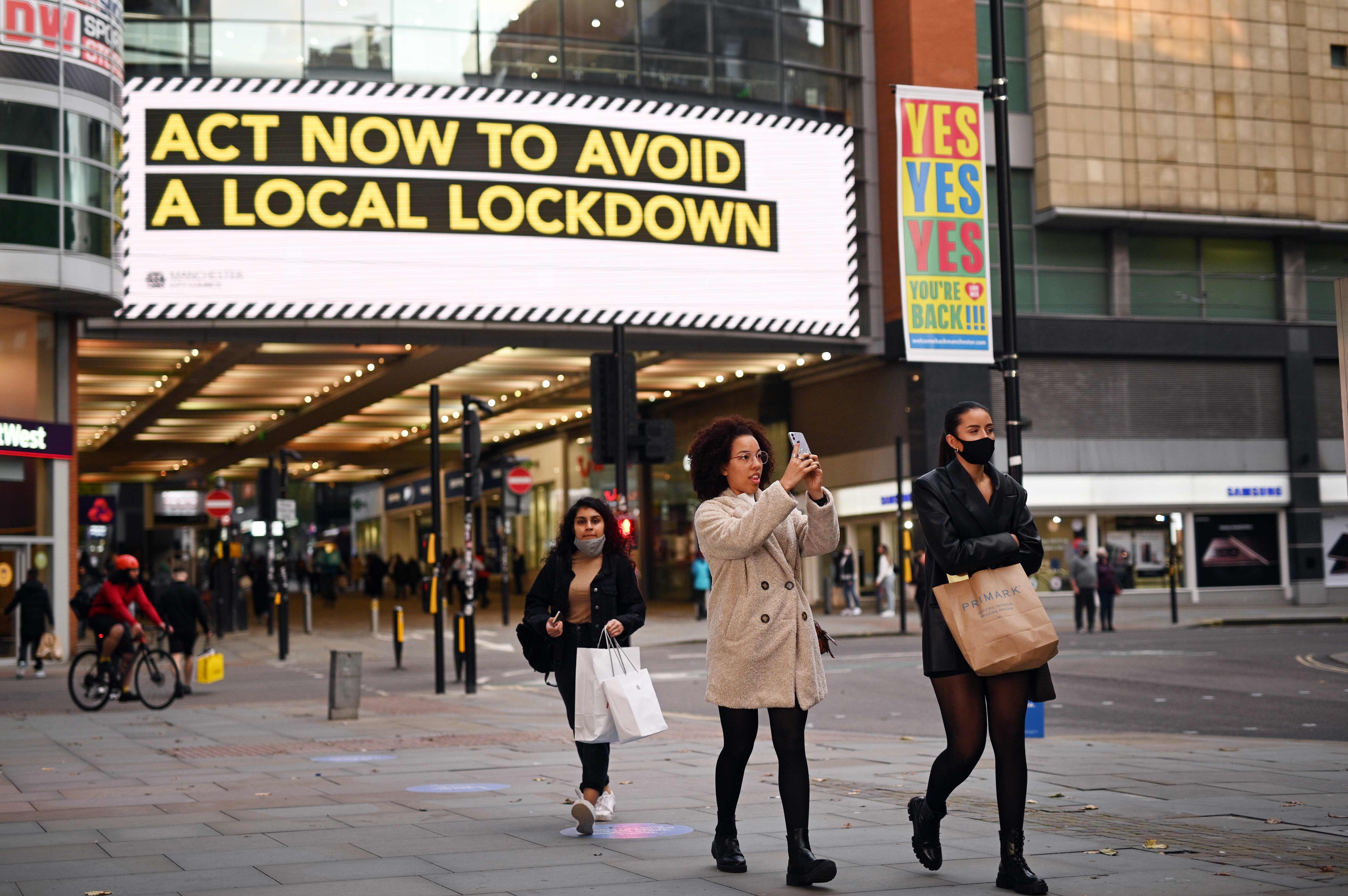 People walk through the shopping area in Manchester