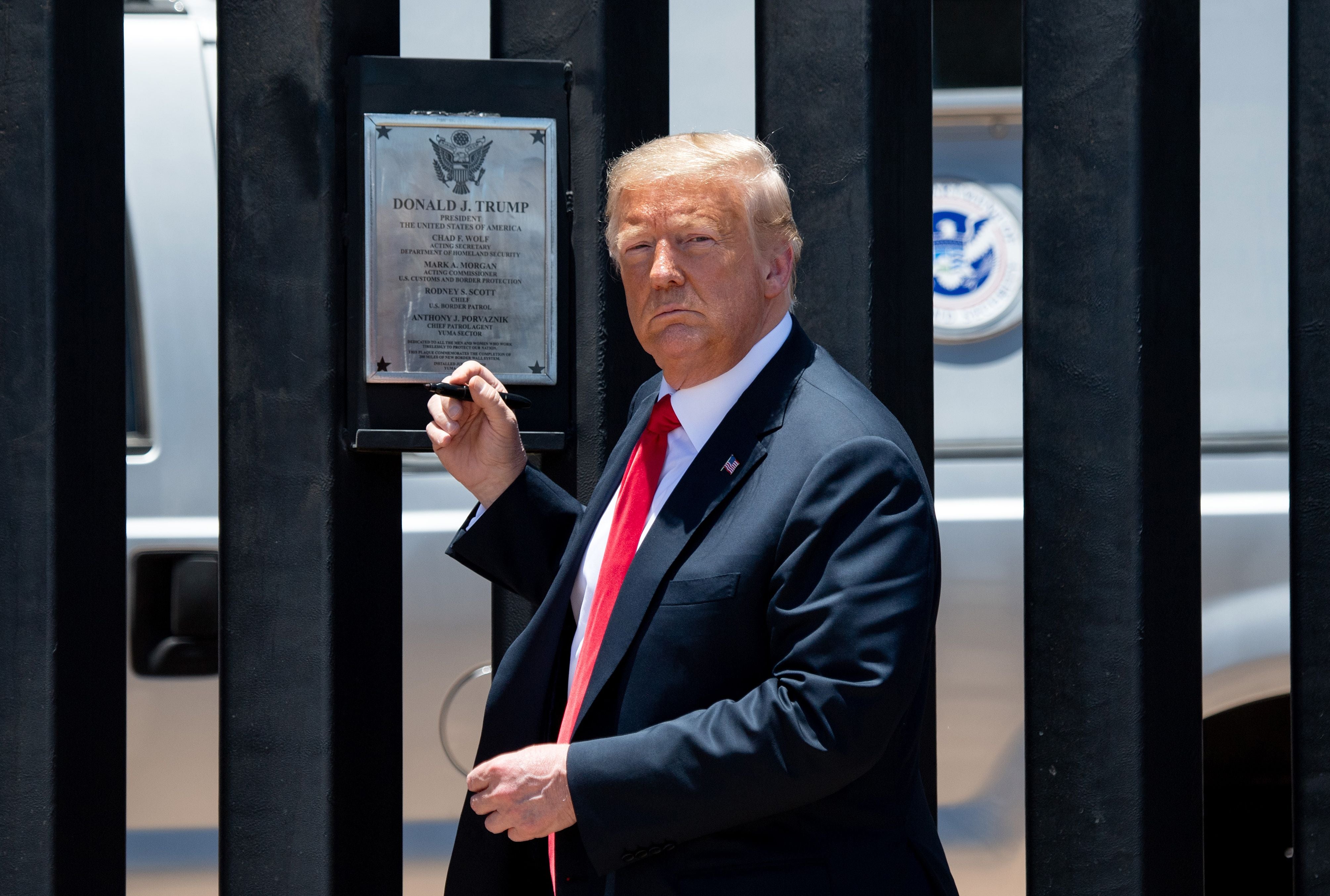 TOPSHOT - US President Donald Trump looks on before signing a plaque as he participates in a ceremony commemorating the 200th mile of border wall at the international border with Mexico in San Luis, Arizona, June 23, 2020. (Photo by SAUL LOEB / AFP) (Photo by SAUL LOEB/AFP via Getty Images)