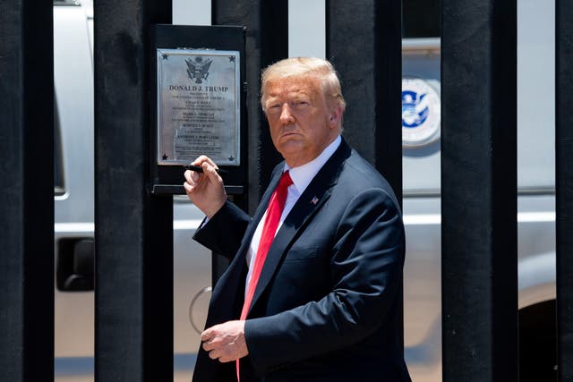 <p>TOPSHOT - US President Donald Trump looks on before signing a plaque as he participates in a ceremony commemorating the 200th mile of border wall at the international border with Mexico in San Luis, Arizona, June 23, 2020. (Photo by SAUL LOEB / AFP) (Photo by SAUL LOEB/AFP via Getty Images)</p>