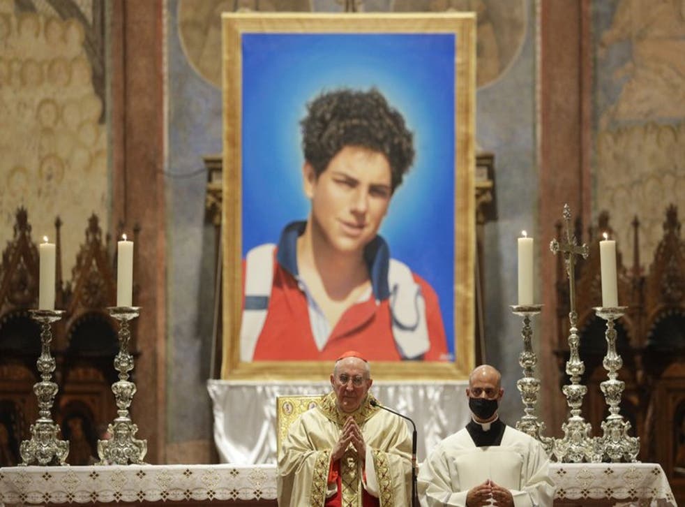 Una imagen del chico italiano Carlo Acutis, de 15 años, que falleció en 2006 de leucemia, es presentada durante su beatificación en una ceremonia a cargo del cardenal Agostino Vallini. (Foto/Gregorio Borgia)