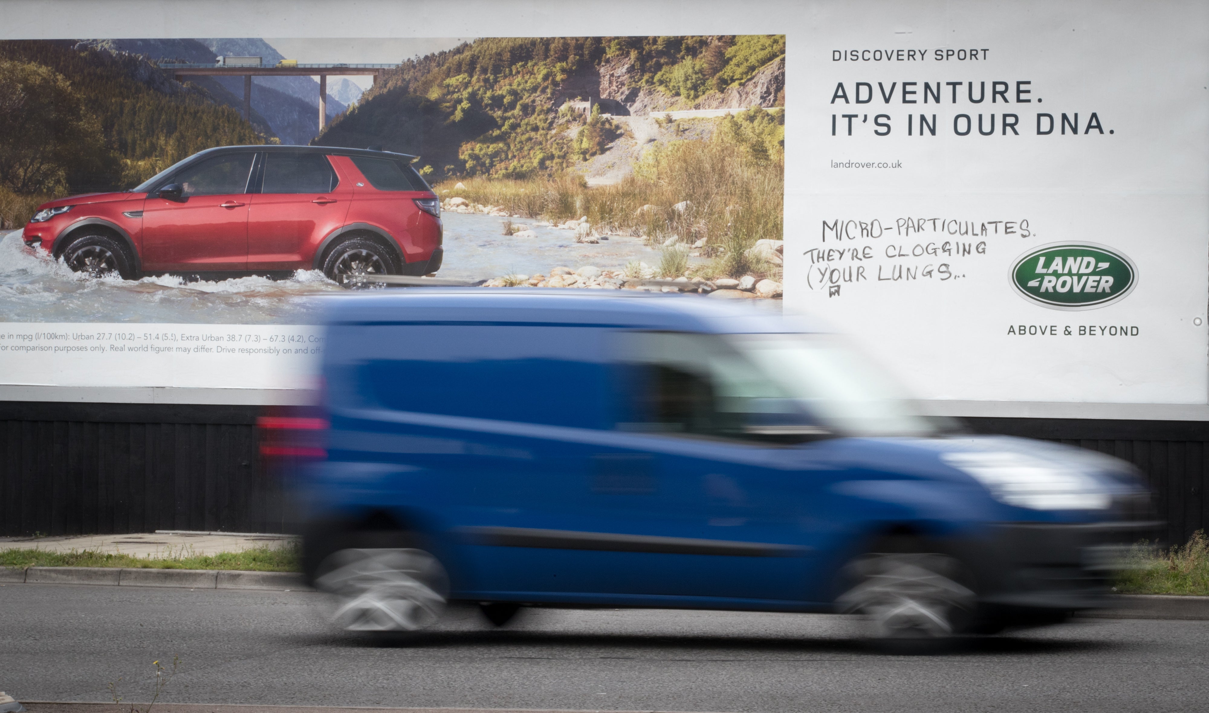 A van passes a poster billboard for a new car that has been graffitied on September 5, 2017 in Bristol, England.