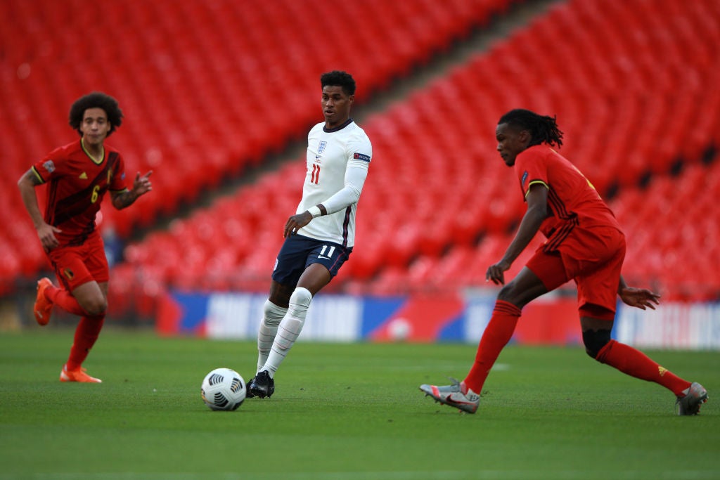 Marcus Rashford of England controls the ball as Axel Witsel of Belgium looks on