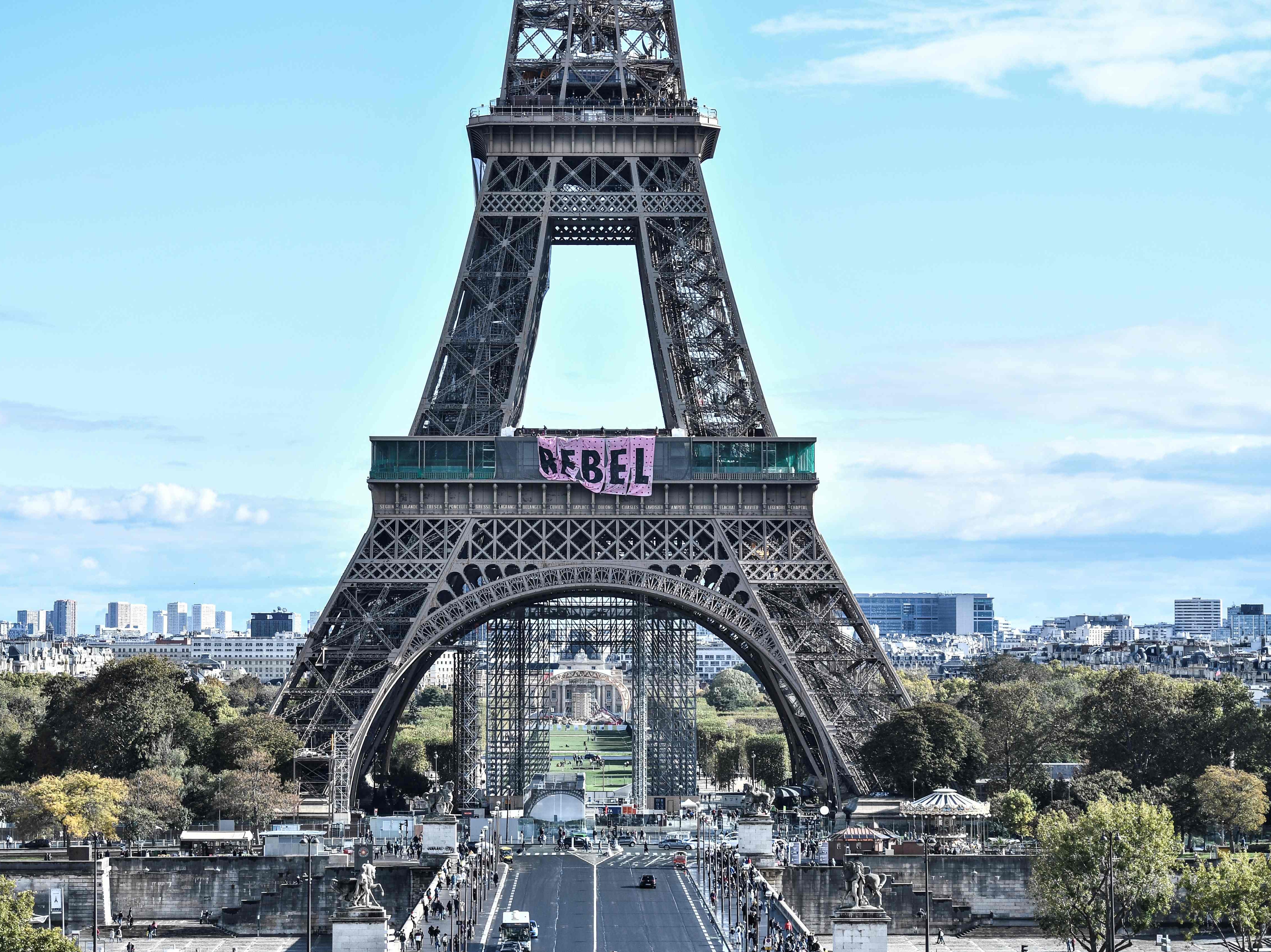 Climate activists hang signs reading “Rebel” off the Eiffel Tower
