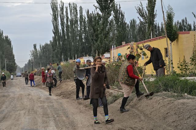 People on a street in a small village where ethnic Uighurs live on the outskirts of Shayar in the region of Xinjiang