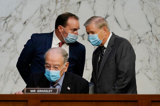 Senator Mike Lee of Utah speaks with Senator Lindsey Graham at the Supreme Court confirmation hearing for Amy Coney Barrett