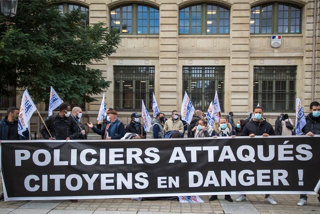 Members of French Police labor unions hold a banner reading “Policemen attacked, citizens in danger!” as they protest outside the Prefecture of Paris