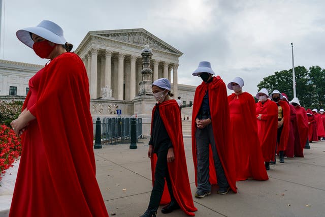 Demonstrators dressed as characters from ‘The Handmaid’s Tale’ oppose Judge Amy Coney Barrett’s confirmation at the Supreme Court on 11 October 2020