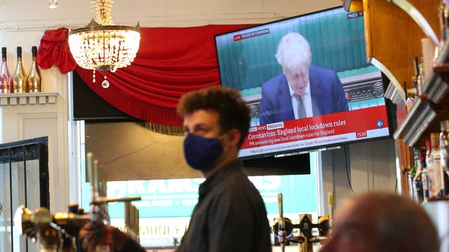 A member of staff pours a drink in the Richmond pub in Liverpool as Prime Minister Boris Johnson reads a statement on television, as parts of the North of England are bracing themselves for the most stringent Tier 3 control