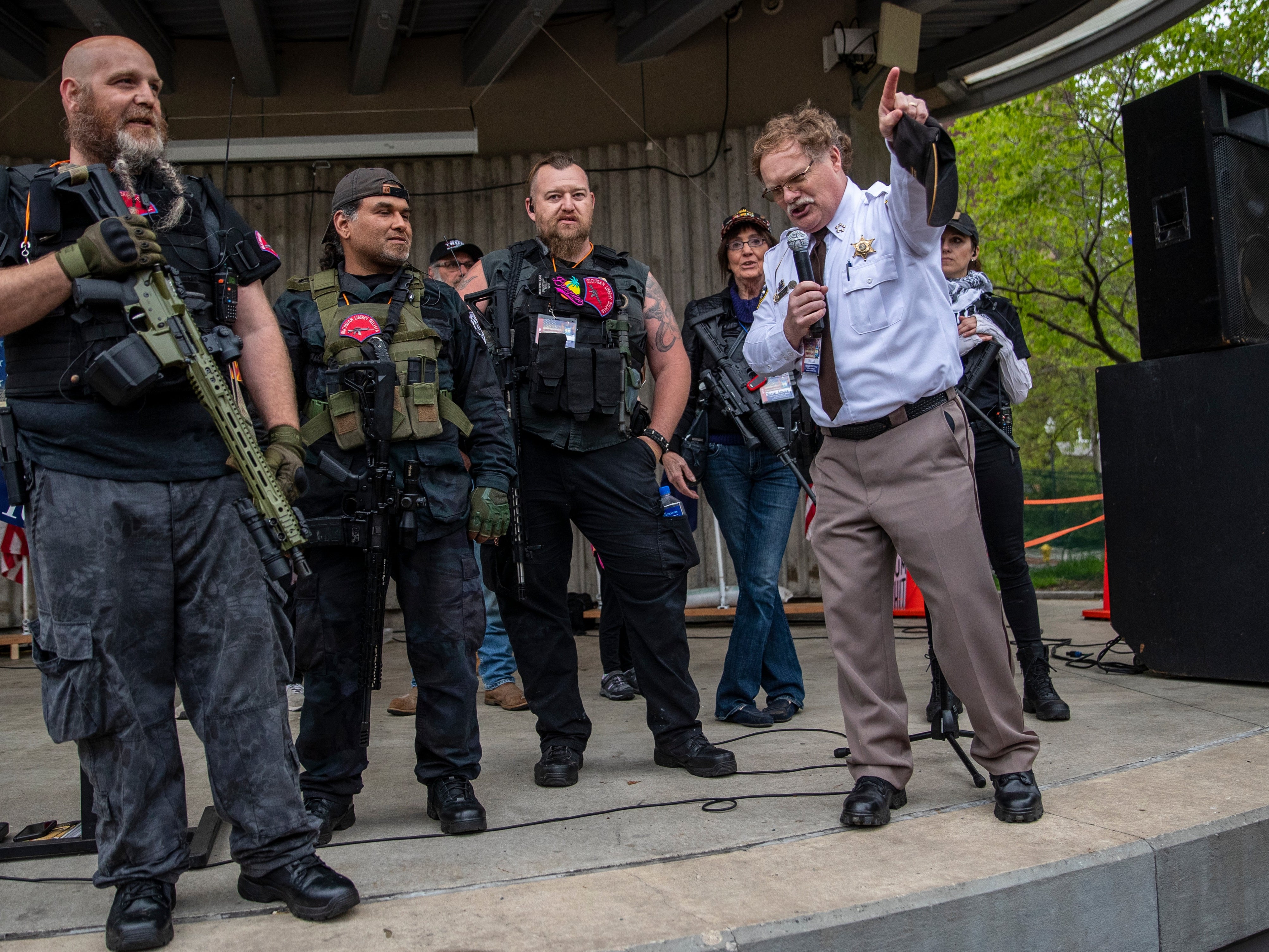 Barry County Sheriff Dar Leaf, front right, speaks next to members of the Michigan Liberty Militia during the “American Patriot Rally-Sheriffs speak out” event at Rosa Parks Circle in downtown Grand Rapids, Michigan, Monday, 18 May, 2020