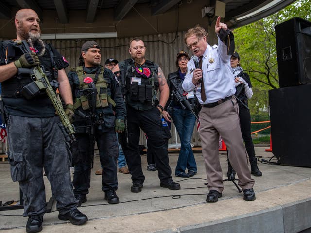 Barry County Sheriff Dar Leaf, front right, speaks next to members of the Michigan Liberty Militia during the “American Patriot Rally-Sheriffs speak out” event at Rosa Parks Circle in downtown Grand Rapids, Mich., Monday, 18 May, 2020