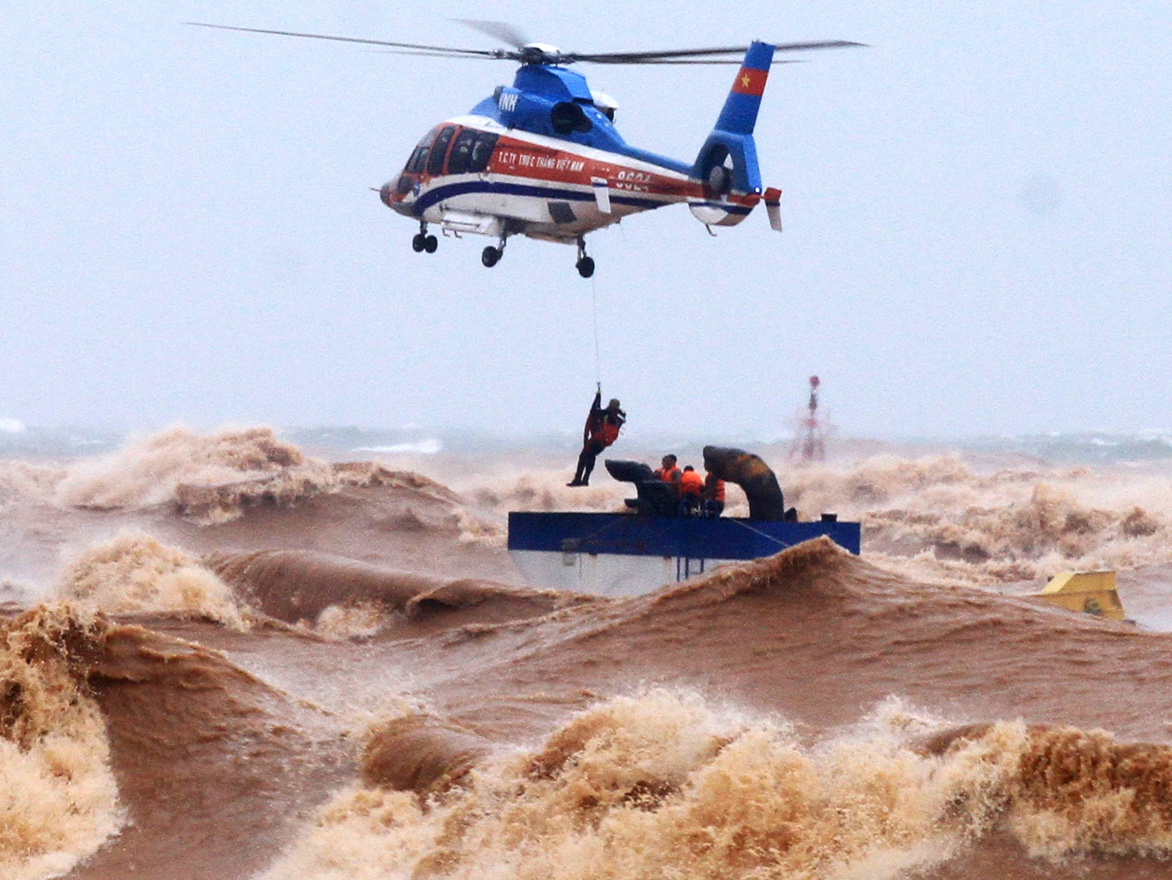 A helicopter crew rescue stranded people from waves in Quang Tri province, Vietnam, on 11 October 2020. Heavy rains and floods killed nine people and left 11 missing during the past few days