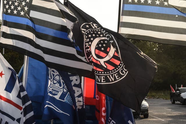 <p>A flag for the QAnon conspiracy theory is flown with other right wing flags during a pro-Trump rally on October 11, 2020 in Ronkonkoma, New York</p>