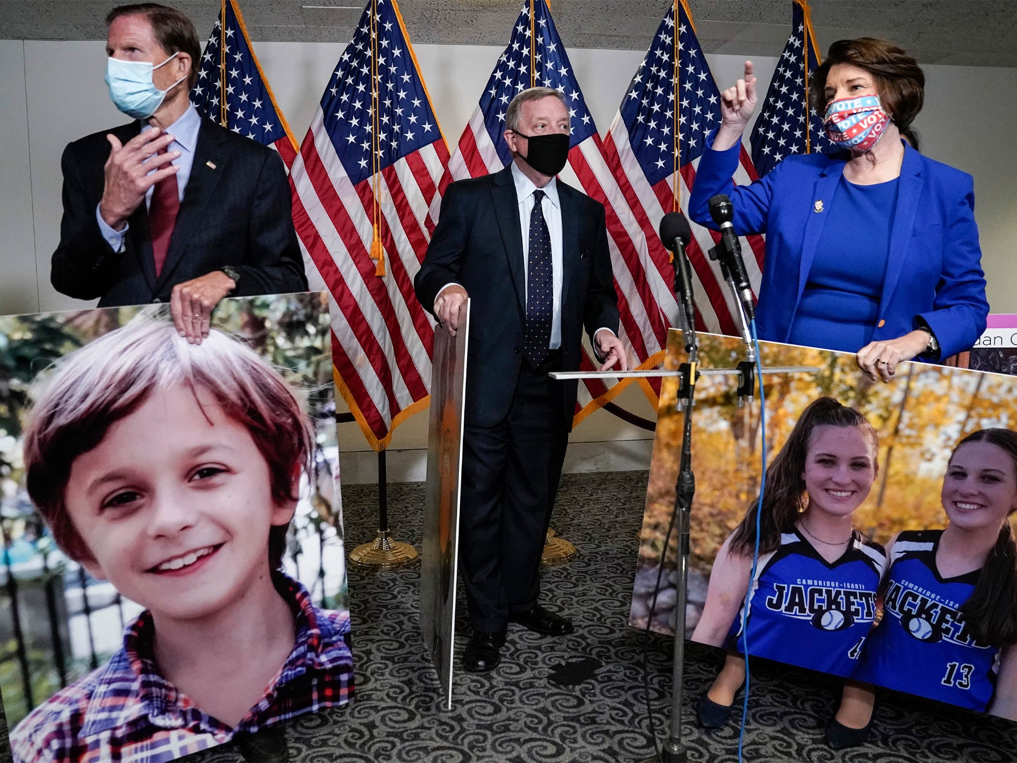 Democratic Senators Richard Blumenthal, Dick Durbin and Amy Klobuchar holding photographs of people who would be impacted by the elimination of the Affordable Health Care Act