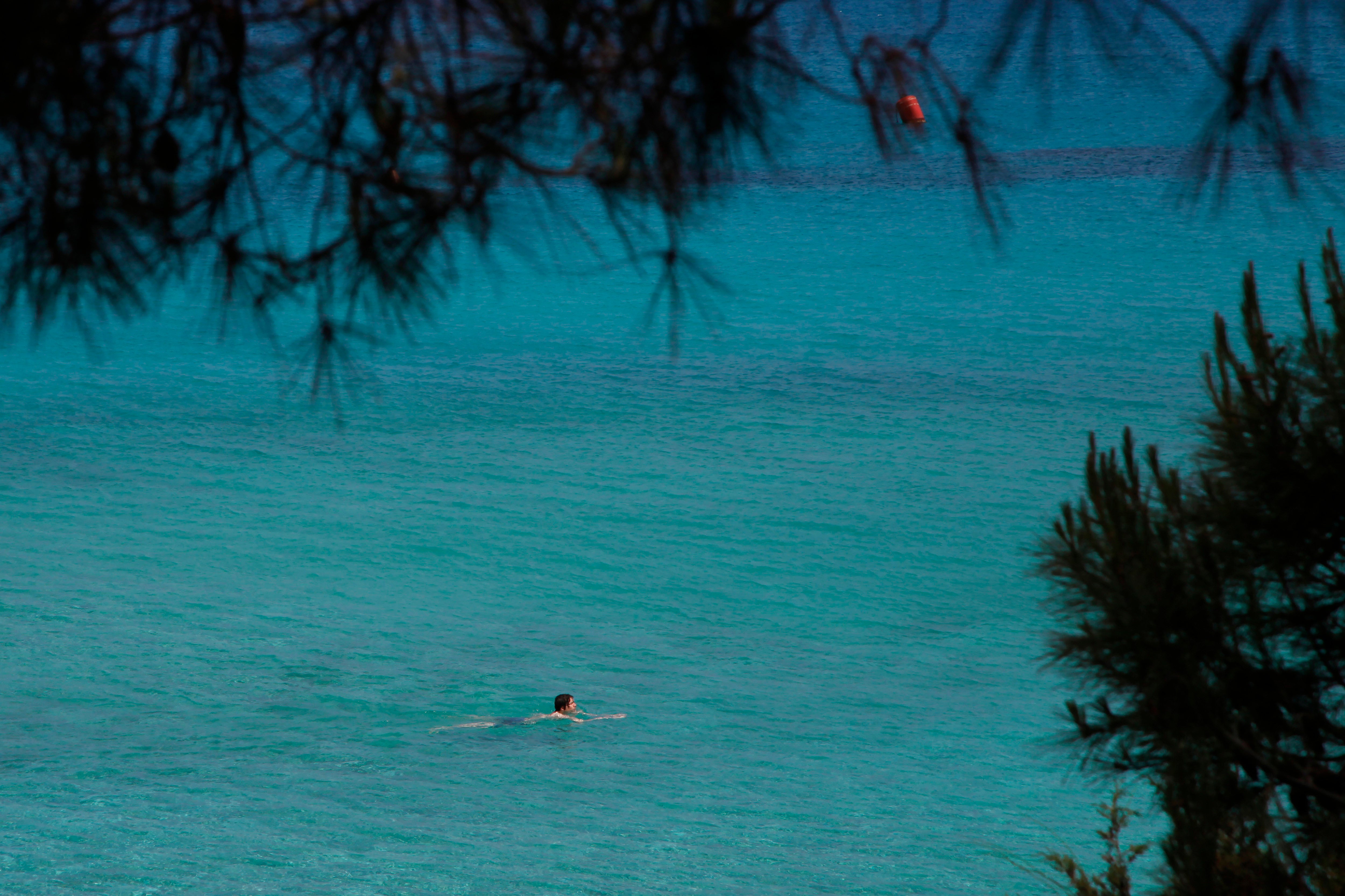A lone person swims through the clear waters of ‘Konnos’ beach in Ayia Napa, Cyprus. Cyprus government spokesman Kyriakos Koushos said that the Cabinet accepted a recommendation by the minsters of the interior and finance to cancel altogether the ‘golden passport’ programme