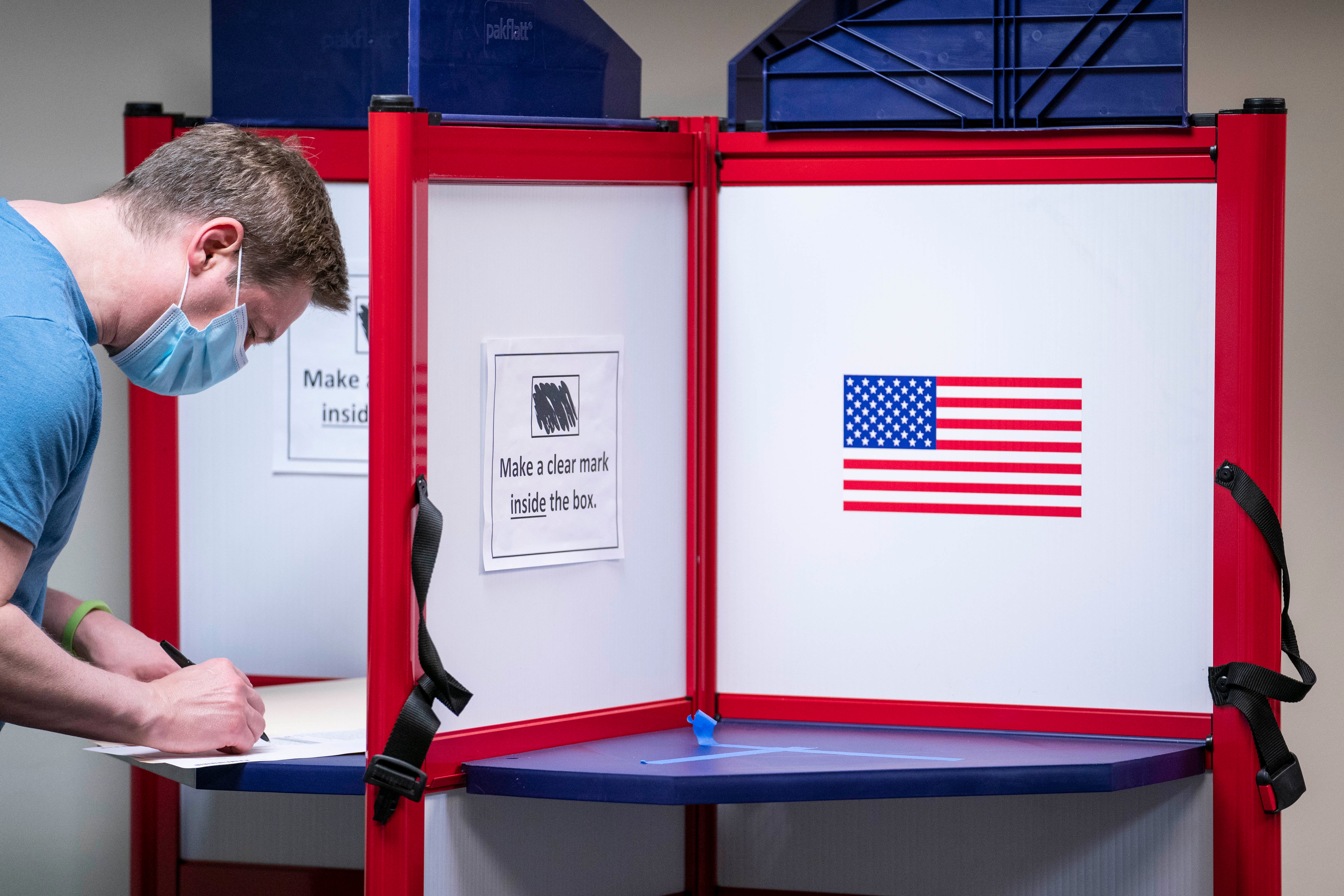 A man casts his ballot for the 2020 presidential election at an early voting location on 1 October in Alexandria, Virginia.