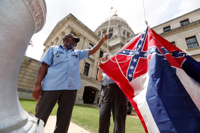 <p>In this 2020 photo, Mississippi Department of Finance and Administration employees prepare to raise the previous state flag over the Capitol grounds in Jackson, Miss. </p>