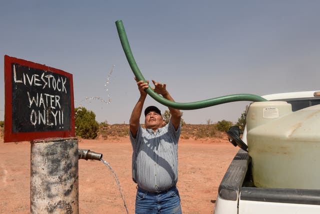 <p>Eugene Boonie, 55, of the Navajo Nation fills up his water tank at a livestock spigot</p>