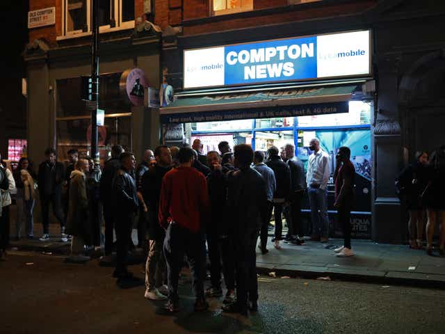 People queuing outside Compton News convenience store in Soho, London, after customers leave pubs and restaurants at 10pm