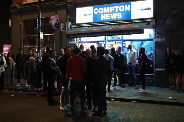 People queuing outside Compton News convenience store in Soho, London, after customers leave pubs and restaurants at 10pm