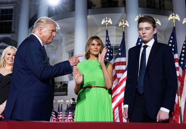 <p>Donald Trump gestures toward his wife Melania Trump and his son Barron Trump </p>