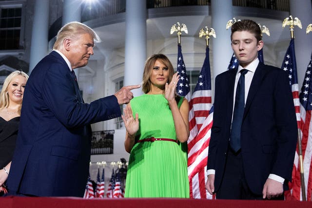 <p>Donald Trump gestures toward his wife Melania Trump and his son Barron Trump </p>