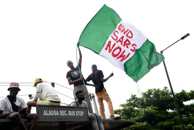 A protester waves the Nigerian national flag during a demonstration in Lagos to campaign for the scrapping of the Special Anti-Robbery Squad (SARS)