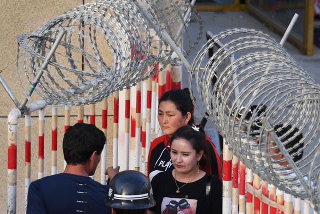 Uighur women are stopped by police as they enter Xinjiang