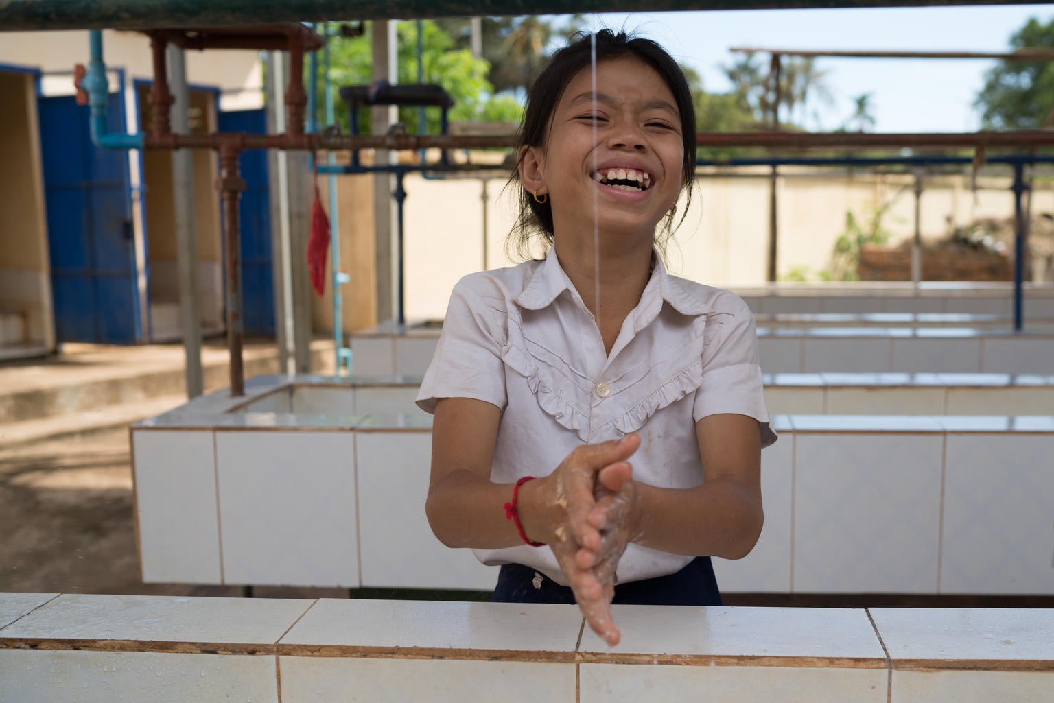A student at the WASH facility at Kampong Thmar Primary School